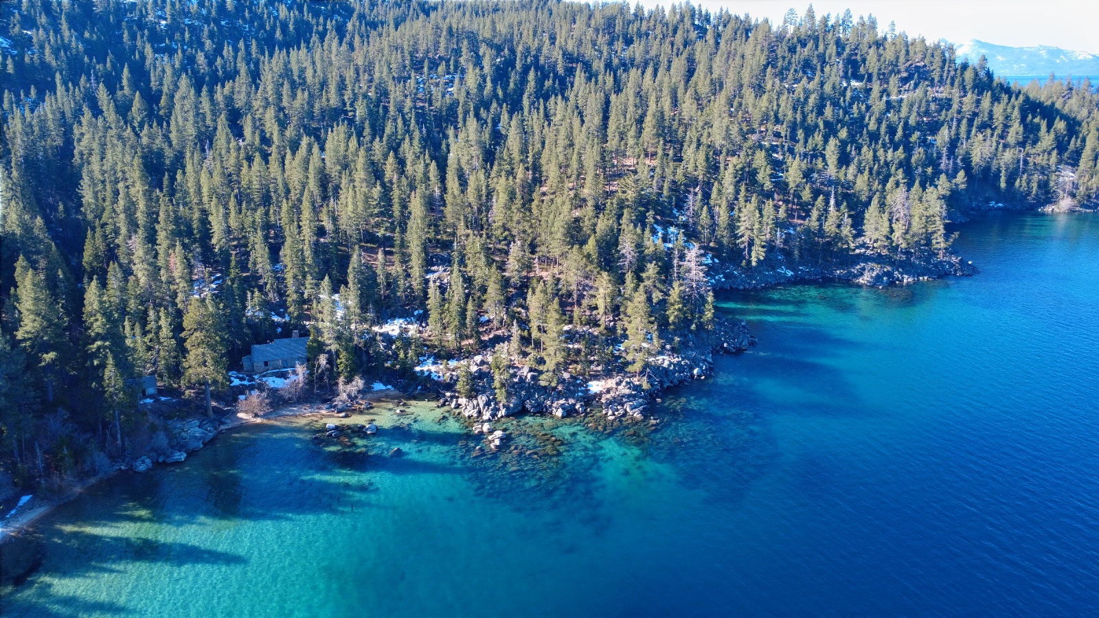 9:33. Pines down to the waterline, a building tucked in at the cove.