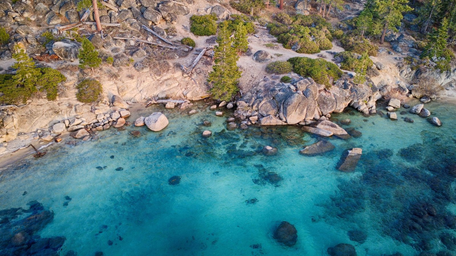 Whale Beach from the drone at 7:00 PM: granite boulders, clear water.