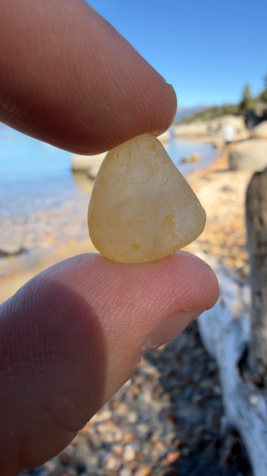 A pale yellow pebble, held up to the light.